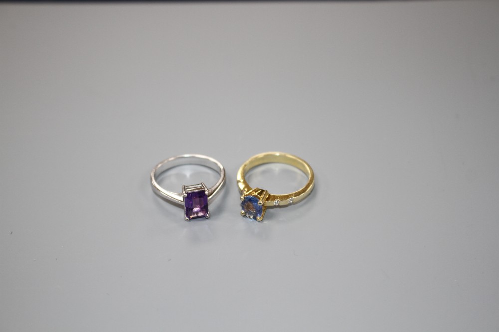A yellow metal and single stone oval cut Ceylon? sapphire ring with diamond set shoulders and a 750 amethyst ring.